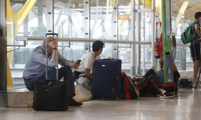 Pasajeros esperando su vuelo este sábado en Barajas.