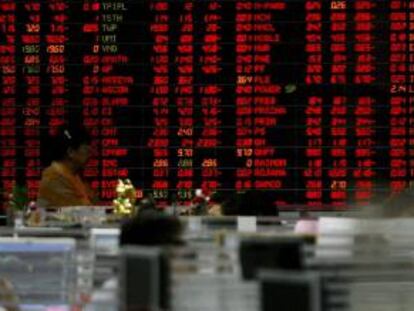 Un inversionista tailandés mira una pared de cifras que muestra los datos del mercado de ganado en la Bolsa de Tailanda en Bangkok. EFE/Archivo