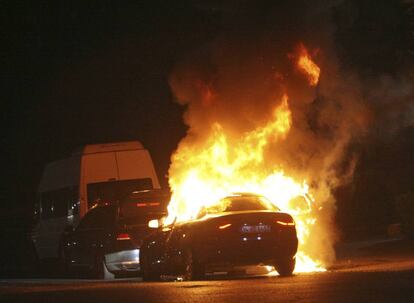 Un coche arde durante el tiroteo entre el ejército turco y la policía turca , en la plaza Taksim de Estambul.