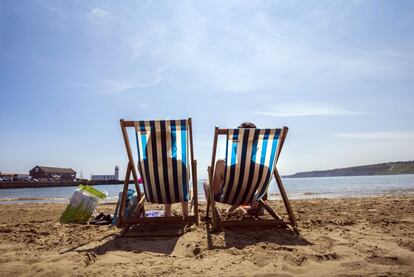 Una pareja disfruta del calor en una playa de  Scarborough, Inglaterra.