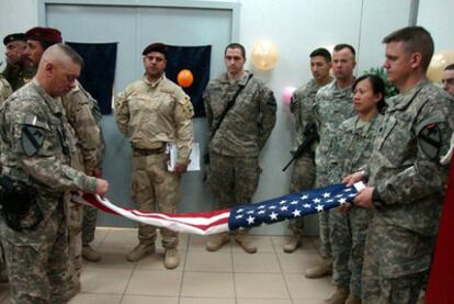 Soldados estadounidenses doblan la bandera durante una ceremonia de traspaso de las instalaciones militares al Ejército iraquí.