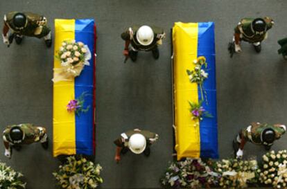 Policías y soldados colombianos montan guardia ante los féretros de Guillermo Gaviria y Gilberto Echeverri durante el funeral oficiado ayer en Medellín.