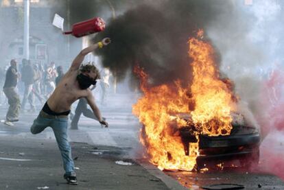 Un manifestante lanza un objeto contra la policía durante los disturbios registrados en Roma.