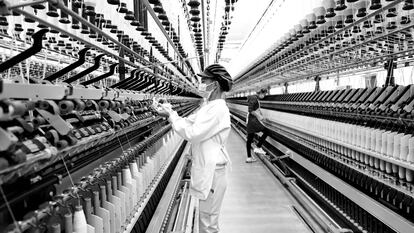 Una empleada maneja una máquina en una fábrica textil en diciembre de 2022, en Ganzhou (China).