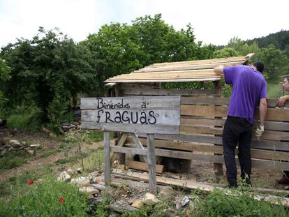 Dos repobladores trabajan en la construcción de un cuarto para la basura en Fraguas. 