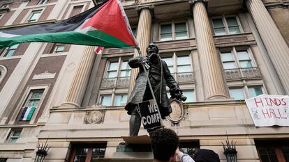 Un estudiante ondea una bandera palestina frente al edificio de la Universidad de Columbia ocupado por manifestantes.