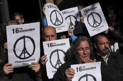 Un grupo de personas con carteles en recuerdo a las víctimas de los atentados de París, durante el minuto de silencio celebrado en la ciudad de Pamplona (España).