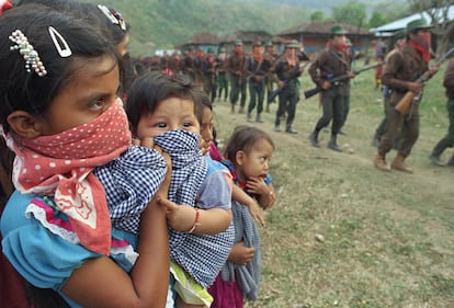 A young indigenous woman watches guerrillas parade for the 75th anniversary of the death of the revolutionary leader Emiliano Zapata, on April 10, 1994.