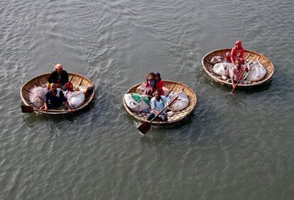 Un grupo de pescadores rema en sus barcas llevando a sus familiares por el lago Vembanad, en Kochi (India).