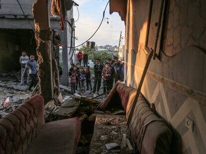 Un grupo de palestinos mira los restos de una casa destruida en un bombardeo en Rafah, este domingo.