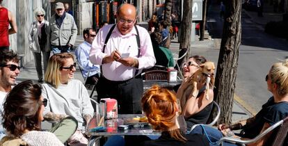 Un autónomo, propietario de un bar en Madrid, atiende a unos clientes.