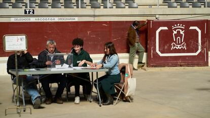 Un hombre observa el burladero del Iradier Arena, que antes era una plaza de toros, detrás de una mesa electoral este domingo, durante las elecciones vascas.