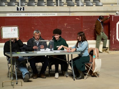 Un hombre observa el burladero del Iradier Arena, que antes era una plaza de toros, detrás de una mesa electoral este domingo, durante las elecciones vascas.