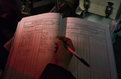 Un oficial realiza anotaciones en el cuaderno de bitácora.