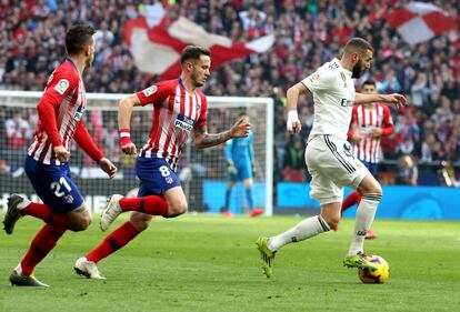 El jugador francés del Real Madrid, Benzema, es presionado por jugadores del Atlético.