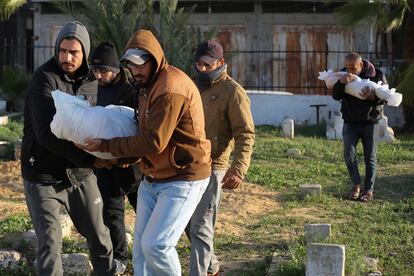Palestinos transportan los cuerpos de niños de la familia Dhair, muertos en un bombardeo israelí, en Rafah, Gaza, el 22 de diciembre de 2023.