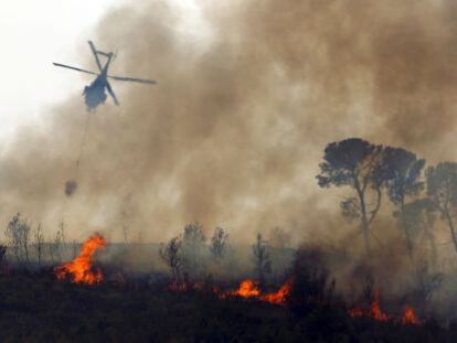 Un helic&oacute;ptero sobrevuela este lunes el fuego durante los trabajos de extinci&oacute;n en los alrededores de Alcublas y Liria.