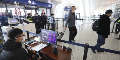 Un operario controla a través de una pantalla la temperatura corporal de los viajeros en el aeropuerto internacional de Wuhan.