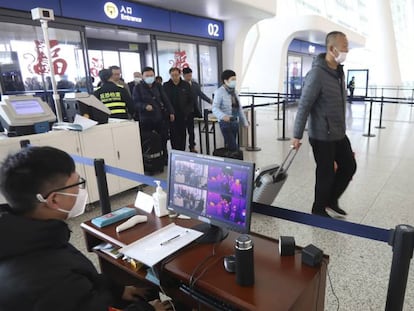 Un operario controla a través de una pantalla la temperatura corporal de los viajeros en el aeropuerto internacional de Wuhan.