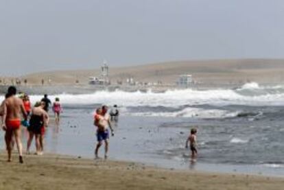 Los turistas pasean por la playa de Maspalomas en la isla de Gran Canaria.