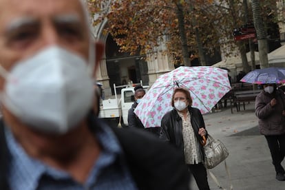 Gente paseando, protegida con mascarillas.