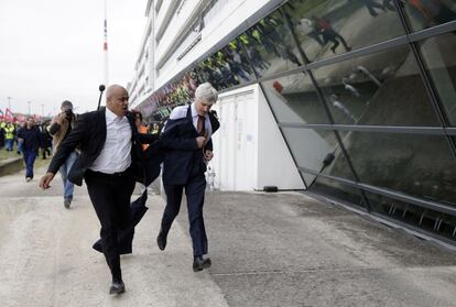 Pierre Plissonnier, directiu de Air France, s'escapa dels manifestants ajudat per un agent de seguretat.