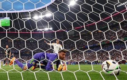 El portero Angus Gunn, de Escocia, observa el balón lanzado por Florian Wirtz en su primer gol.