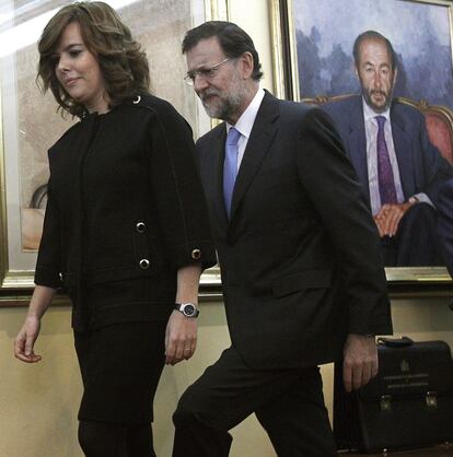 El jefe del Ejecutivo, Mariano Rajoy, acompaña a Soraya Sáenz de Santamaría durante la toma de posesión de esta como vicepresidenta, ministra de la Presidencia y portavoz del Gobierno, en un acto celebrado en el Palacio de la Moncloa.