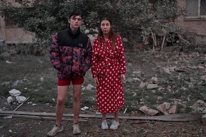 Dos jóvenes reaccionan en el lugar de un edificio residencial alcanzado por un misil ruso, este jueves.