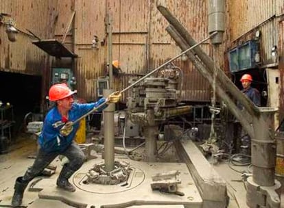 Dos empleados trabajan en el campo petrolífero de Yuzhno-Lokosovskoje (Siberia), de la empresa OAO Slavneft.