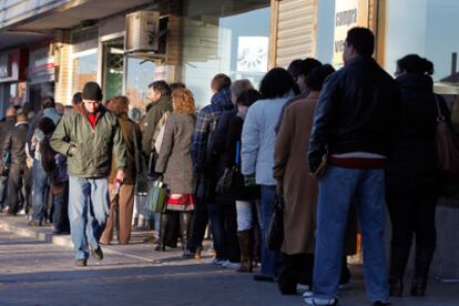 Un grupo de personas hace cola frente a una oficina de desempleo en el barrio de Santa Eugenia de Madrid.