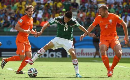 Daley Blind y Ron Vlaar vigilan a Oribe Peralta durante una jugada.