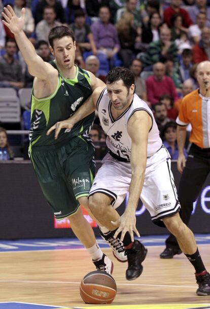 Mumbrú avanza con el balón perseguido por el alero del Unicaja Pablo Almazán.