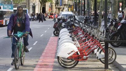 Un ciclista passeja al costat d'una parada del Bicing l'any 2007, quan es va inaugurar el servei de lloguer públic.