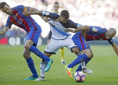 Mascherano (d) y Sergio Busquets (i), luchan por el balón ante el extremo del Deportivo de La Coruña Bruno Gama.