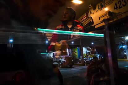 Un voluntario de Cruz Roja da agua y comida a los centroamericanos en el interior de un autobús en Caborca, Sonora.