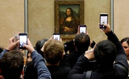 Visitantes do Louvre tiram fotos da ‘Mona Lisa’, em 3 de dezembro.