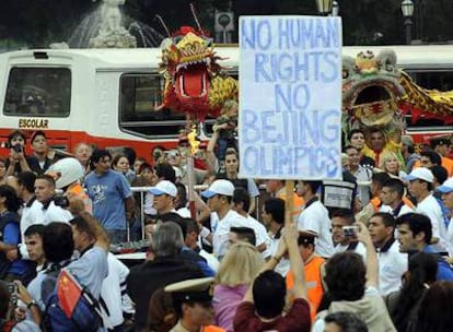 Un atleta porta la llama olímpica entre manifestantes contra China ayer en Buenos Aires.