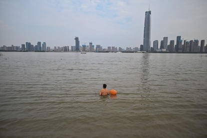 Un hombre se prepara para nadar en el río Yangtze en Wuhan, en la provincia central de Hubei (China), donde surgió el nuevo coronavirus. Estados Unidos sigue siendo el país más afectado a nivel mundial por la pandemia, con 7,14 millones de personas contagiadas y 205.085 víctimas mortales, tras sumar más de 33.000 casos nuevos desde el balance anterior.