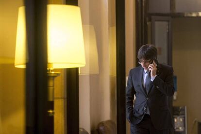  El presidente de la Generalitat, Carles Puigdemont, habla por tel&eacute;fono en los pasillos del parlamento de Catalu&ntilde;a.