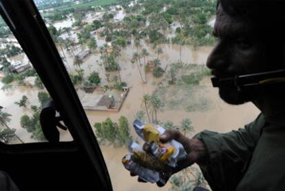 Un soldado paquistaní a bordo de un helicóptero se dispone a lanzar bolsas de comida a los afectados por las riadas en la provincia de Punjab.