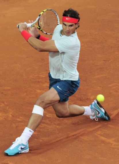 Nadal devuelve la pelota ante Raonic.