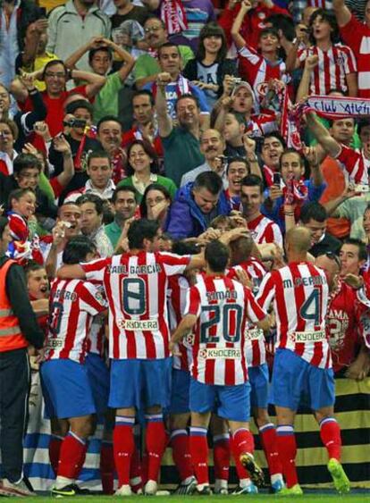 Los jugadores del Atlético abrazan a Forlán tras el gol.