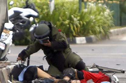 Un artificiero inspecciona un cadáver en el lugar donde se ha producido una explosión cerca de un centro comercial en Yakarta (Indonesia).