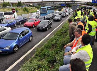 Transportistas en huelga contemplan el atasco de coches en la A-1.