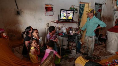 Una familia observa en una favela el partido entre Brasil y México.