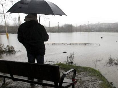 Vecinos de Hernani, observan el campo de rugby Landare, anegado por el desbordamiento del río Urumea.