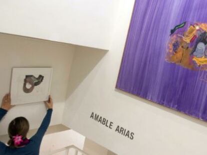 Una mujer coloca una de las obras de Amable Arias que se podrán ver en la galería donostiarra Ekain Arte Lanak a partir del próximo miércoles.