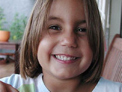 Una niña con dientes de leche se prepara para la higiene bucal.