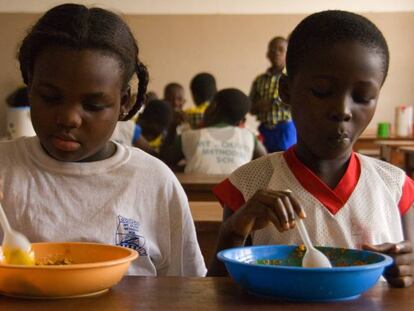 Unos ni&ntilde;os comen en el comedor de su colegio en Ghana.